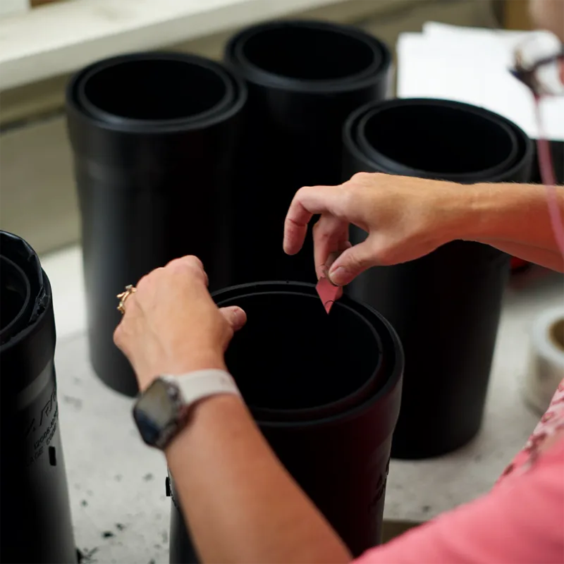 Hands inspecting custom molded rubber components during production process